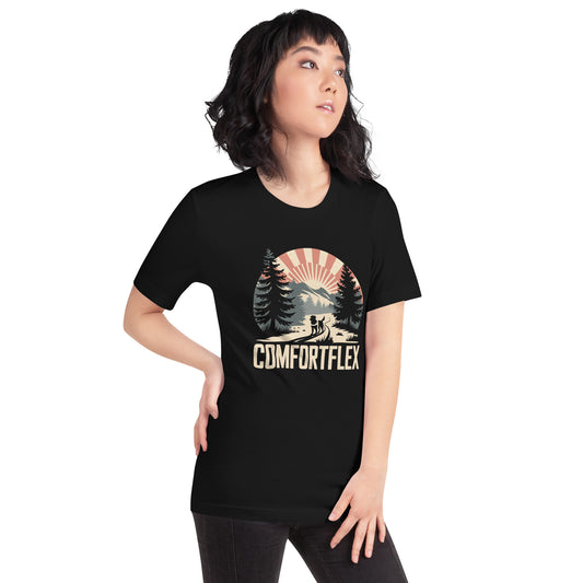 Woman wearing a black ComfortFlex T-shirt featuring a retro-style outdoor graphic with trees, mountains, and sun rays.